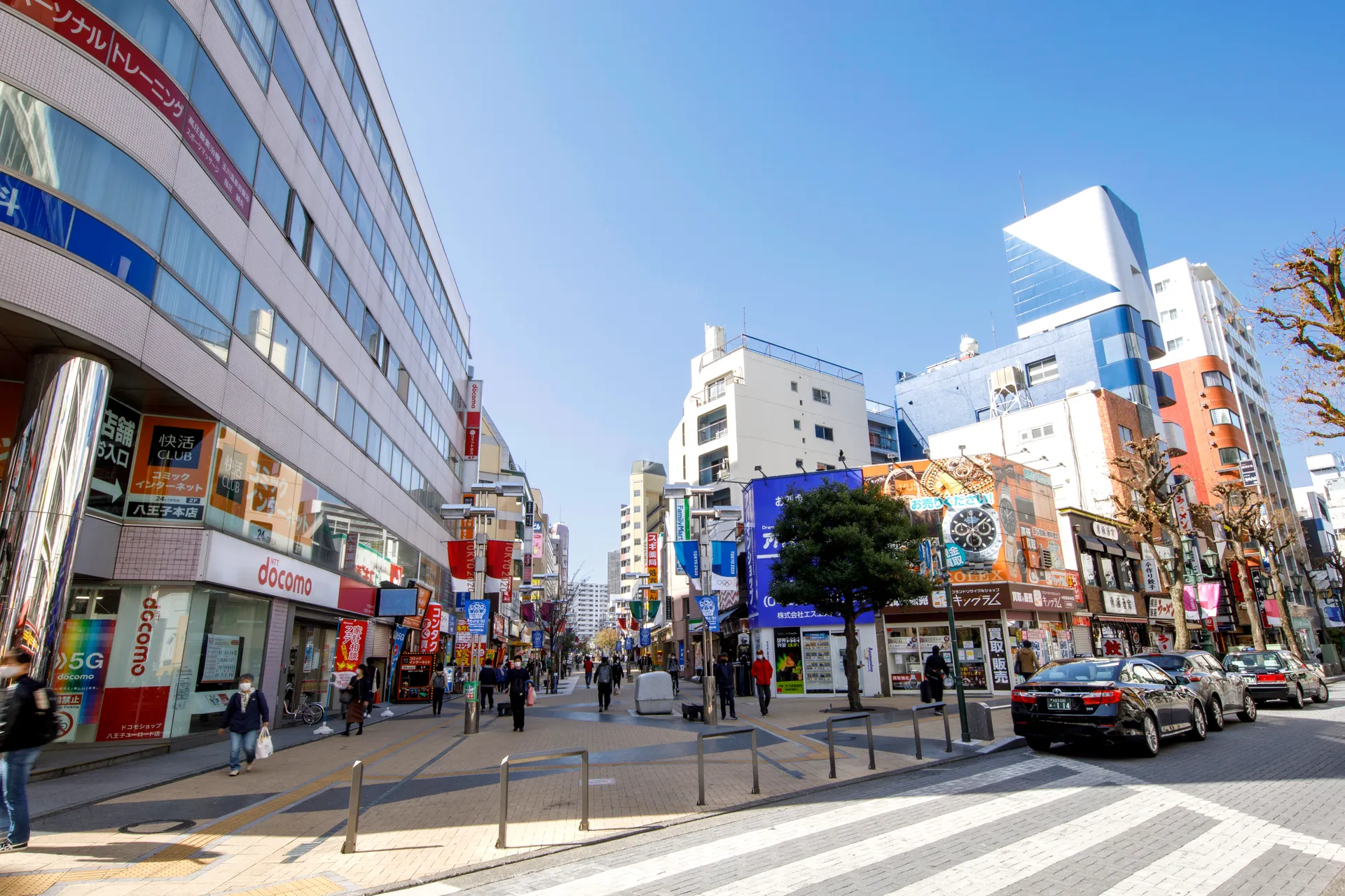 青空の下、西放射線ユーロードの歩行者天国を行き交う人々と商店の並ぶ街並み